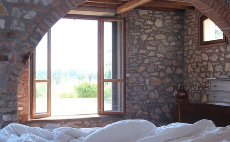 Zimmer mit geöffnetem Fenster und Blick ins Grüne