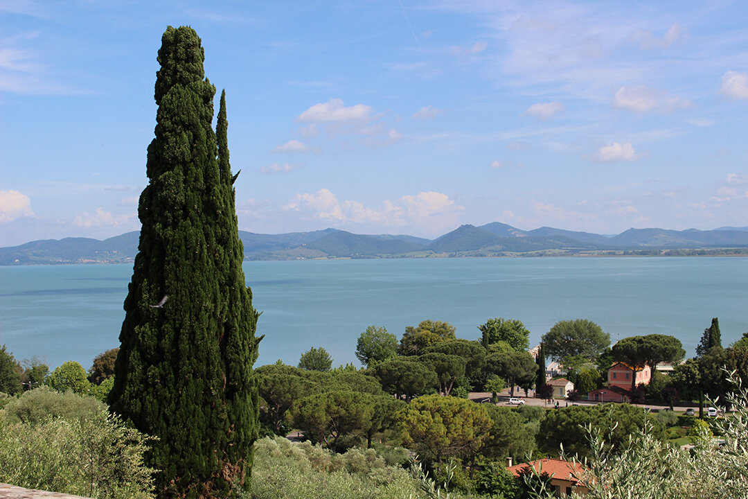 Lago Trasimeno mit grüner Landschaft im Vordergrund
